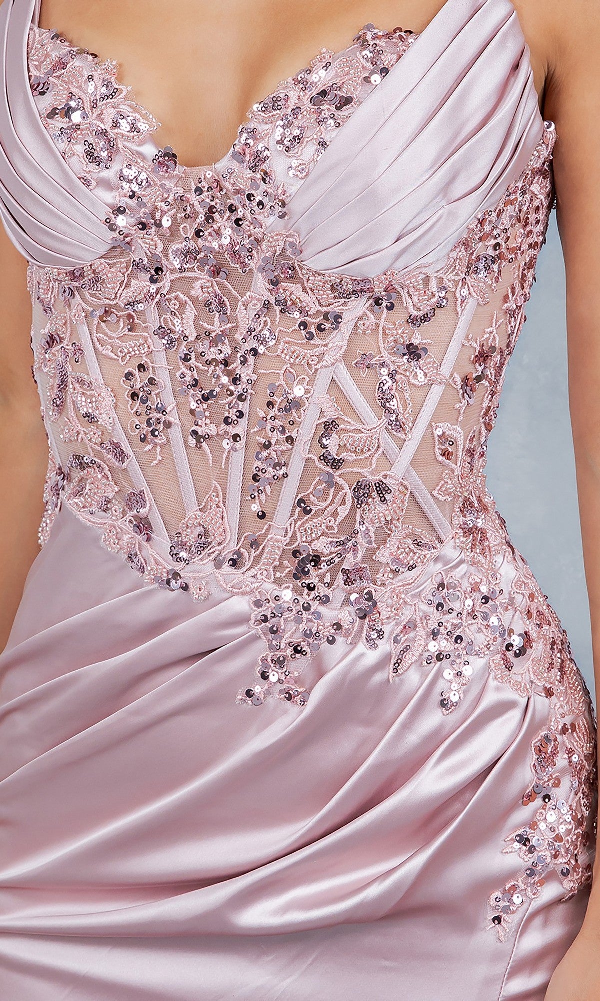 A close-up of a person wearing the Cinderella Couture 8377J long prom dress, featuring a pink satin finish, lace corset bodice with sequin and bead details, sheer panels, and elegantly draped fabric.